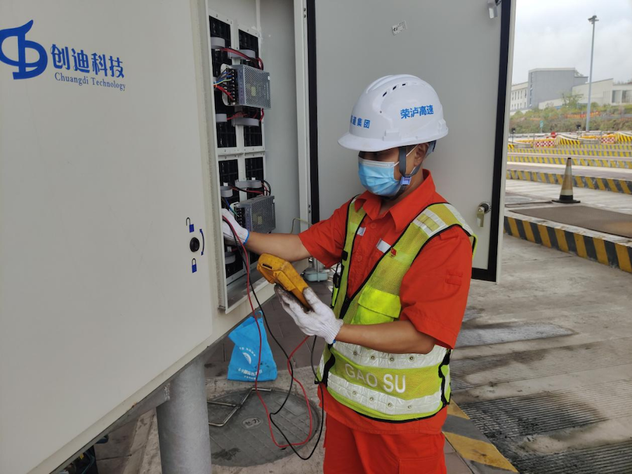 瀘渝公司機電維護隊黨員堅守崗位，維修綠色通道費額顯示器.png